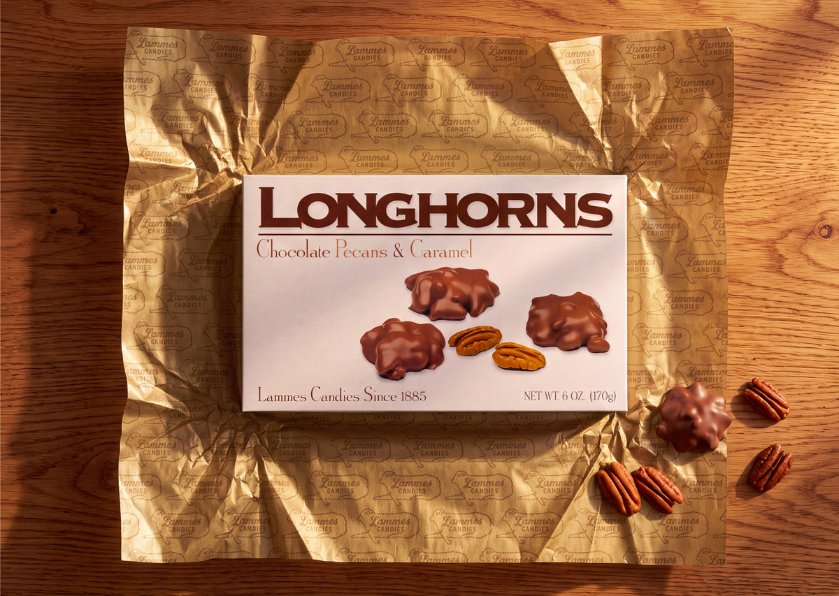 A box of Lammes Longhorns on gold foil with loose pecans
